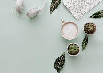 Neutral Minimalist Flat Lay Scene With coffee, keyboard, headphones and cactus