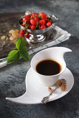 Wild strawberries and cup of black coffee