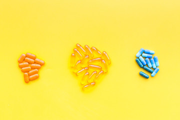 Color capsules. Medicine pills on yellow background top view copy space