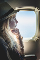 Young Woman Alone Looking Outside and Sitting inside Airplane