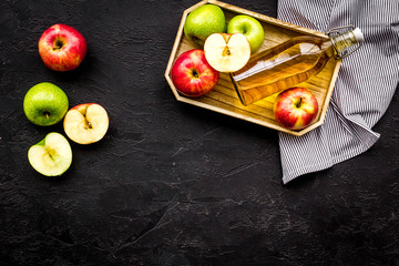 Fototapeta na wymiar Bottle of fresh cider near autumn apples. Black background top view space for text