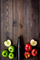 Apple cider. Low-alcoholic beveradge in dark bottle on dark wooden background top view copy space