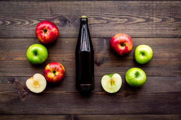 Apple cider. Low-alcoholic beveradge in dark bottle on dark wooden background top view