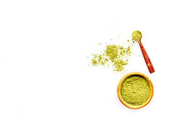 Powdered matcha green tea in bowl and scattered on white background top view copy space