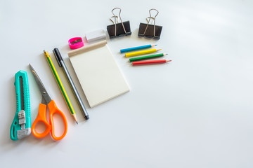 White office desk table with Scissors,Cuttere,Eraser and pencil .Top view with copy space.Working desk table concept.