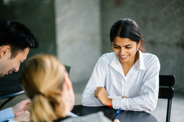 A young and attractive Asian Indian woman is being interviewed for a job. Her interviewers are...
