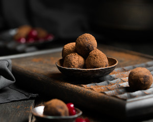 Chocolate truffle. Dark chocolate and cherry candy sprinkled with cocoa on a dark wooden background in rustic style. Atmospheric food photo.  Homemade fresh energy balls.