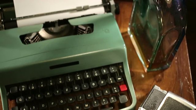 Typewriter and polaroid camera on table.