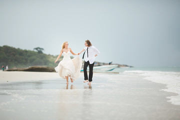 the couple running on the sea. Wedding on a deserted beach.