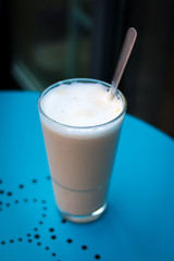Latte Macciato in einem Glas mit Löffel