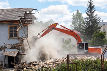 excavator working at the demolition of an old residential building - obrazy, fototapety, plakaty