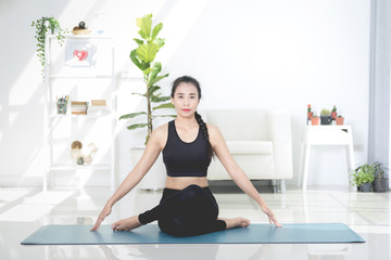 Beautiful asian sports woman performs the exercises at home .Yoga