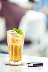 Glasses of iced tea with mint on wooden coaster background .