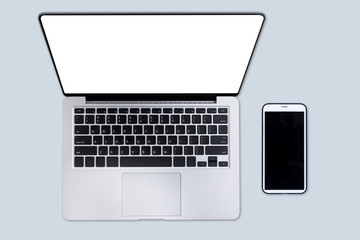 Laptop with cellphone on gray background isolated