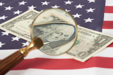 Eine Lupe, Flagge von USA und Dollar Geldscheine