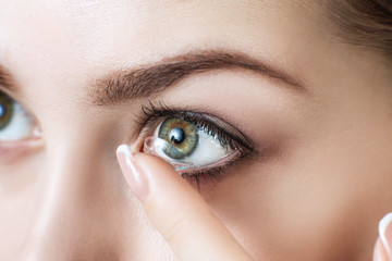 Close-up shot of young woman wearing contact lens. - 192922570
