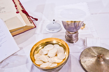 pisside and chalice contain wine and hosts on the altar of the mass