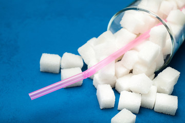 Glass with pink straw with sugar cubes.