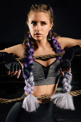 Sexy boxing girl leaned kneels on ropes of competition ring. Fashionable portrait.