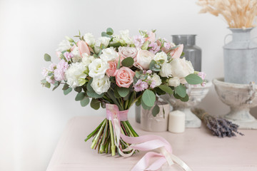 beautiful luxury bouquet of mixed flowers on pink table. the work of the florist at a flower shop. Wedding