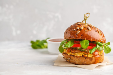 Vegan lentils burger with vegetables and curry sauce. Light background, copy space. Healthy vegan food concept. - obrazy, fototapety, plakaty
