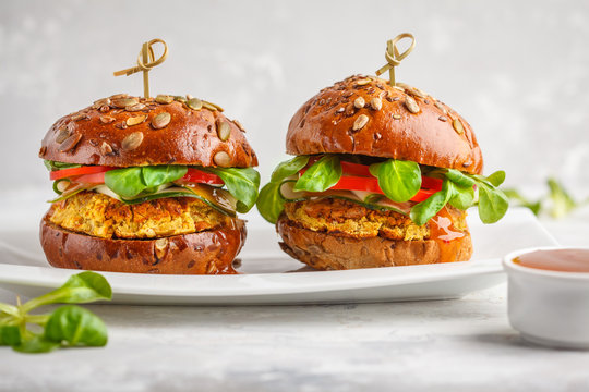 Vegan lentils burgers with vegetables and curry sauce on white dish. Healthy vegan food concept.