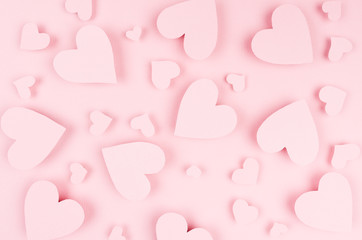 Valentine day background of many different paper hearts on pink soft background.