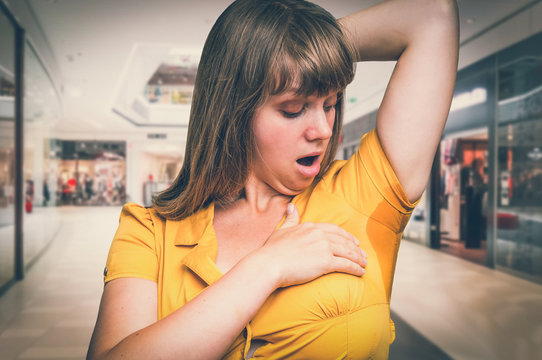 Woman with sweating under armpit in shopping center