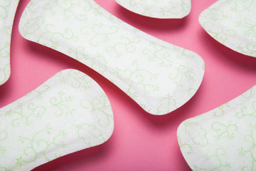 Pattern made of sanitary pads on a pink background.