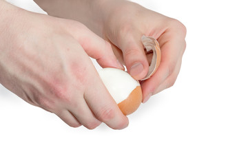 Boiled chicken egg in human hands during cleaning from eggshell