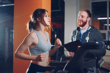 the coach in the gym teaches the girl stretching