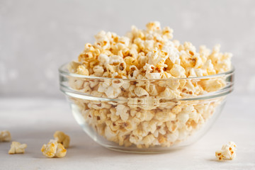 Golden caramel popcorn in glass bowl, copy space.