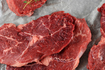 Some raw beef steaks on parchment paper. View from above. Close-up. Macro photography. 