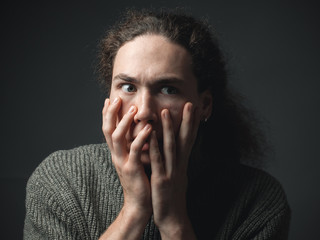 A young man in fear. Studio