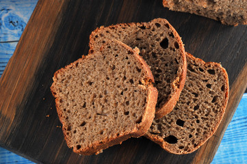 Several pieces of rye bread on a dark wooden board. Close-up. Macro photography.