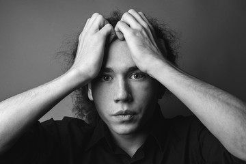 A young guy poses in studio. Black and white