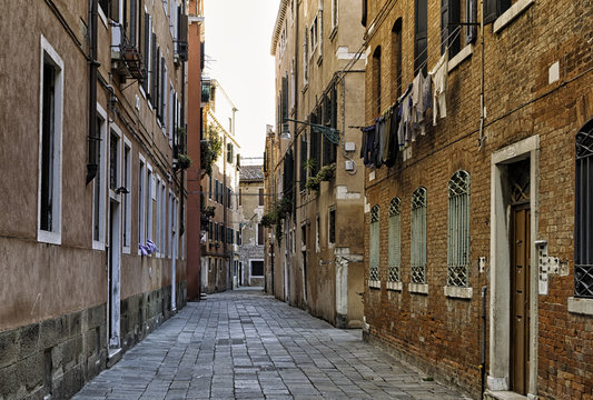 Typical old empty halley in the city of Venice, Italy. Old red bricks and concrete buildings in the Venice lagoon. Traditional italian architecture