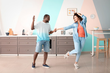 Fototapeta na wymiar Cute interracial couple dancing at home