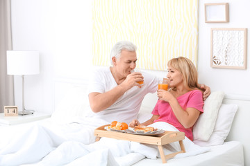 Obraz na płótnie Canvas Mature couple having breakfast in bed. Romantic morning