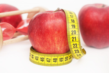 Lose Weigh. close Up of Measuring Yellow Tape Ties Around Red Apple with Glass Sand Clock Isolated on white background. horizontal image with copy space for Text.