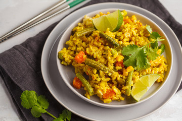 Vegetarian curry rice with vegetables in a gray plate. Healthy vegan food concept, detox, vegetable diet.