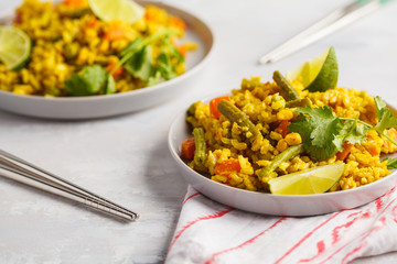 Vegetarian curry rice with vegetables and coconut cream in gray plates. Healthy vegan food concept, detox, vegetable diet.