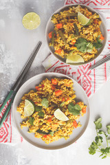Vegetarian curry rice with vegetables and coconut cream in gray plates. Top view, copy space, food background. Healthy vegan food concept, detox, vegetable diet.