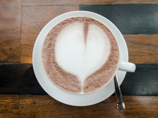 top view of a cup of hot chocolate with heart on wood table