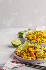 Vegetarian curry rice with vegetables and coconut cream in gray plates. Copy space, food background. Healthy vegan food concept, detox, vegetable diet.