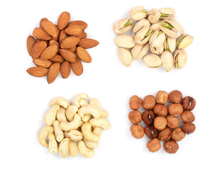 mixed of nuts heap isolated on white background. Almonds, cashews, hazelnuts and pistachio. Top view. Flat lay