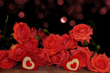красивая розовая роза и фигурка сердца на черном фоне на деревянных досках        
