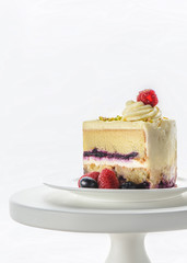 piece of appetizing cake on white cake stand isolated on white