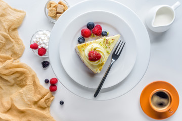 top view of piece of cake with berries on white table