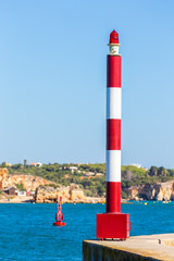 Beacon and buoy with blue water at coast